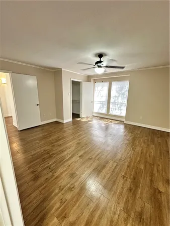 an empty room with wooden floor and windows