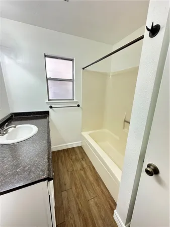 a bathroom with a granite countertop sink a mirror and a bathtub