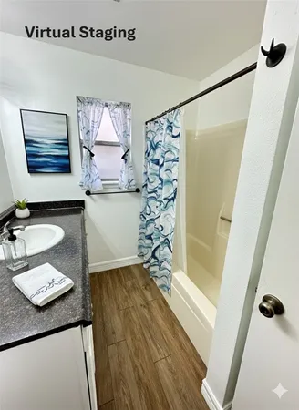 a bathroom with a granite countertop sink a mirror and shower