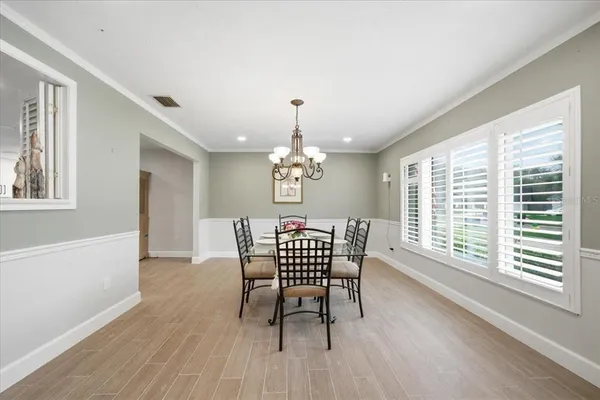 a dining room with furniture a chandelier and wooden floor
