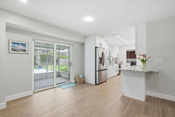 a view of a kitchen with refrigerator and wooden floor