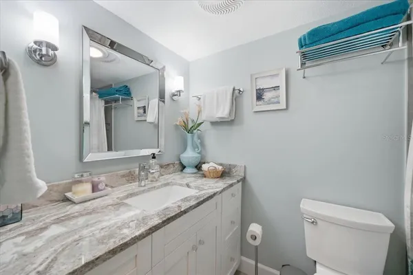 a bathroom with a granite countertop sink mirror and toilet
