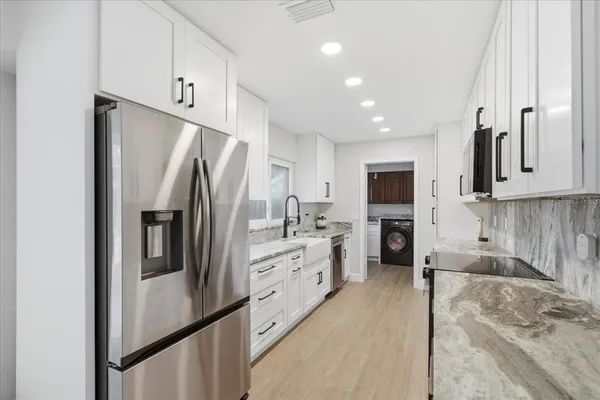 a kitchen with stainless steel appliances a refrigerator sink and cabinets