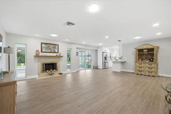 a view of an empty room with a fireplace and window