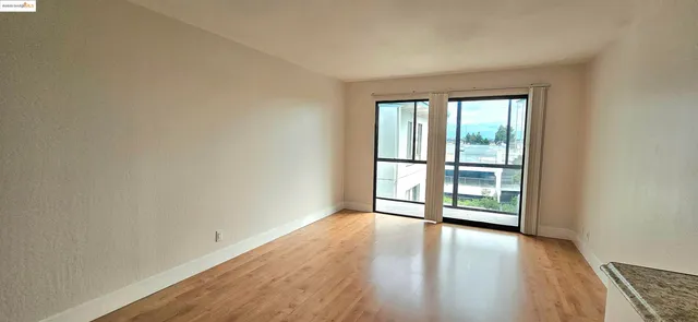 a view of a room with wooden floor and a window