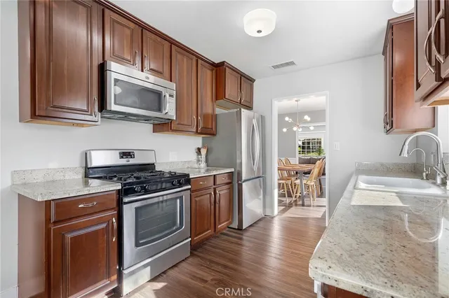 a kitchen with stainless steel appliances granite countertop a stove a sink and a microwave