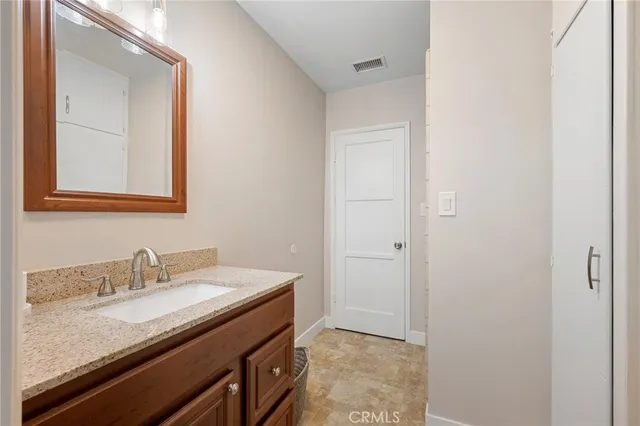 a bathroom with a granite countertop sink and a mirror