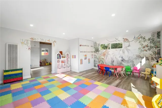 a playing room with furniture and a wooden floor