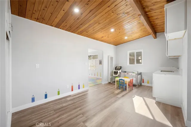 a living room with furniture and a dining table with wooden floor
