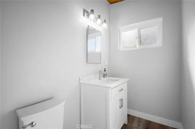 a bathroom with a toilet a sink a vanity and mirror