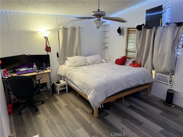 a bedroom with a bed wooden floor and a chair