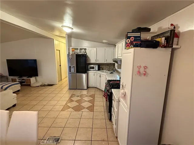 a view of a kitchen with fridge and workspace