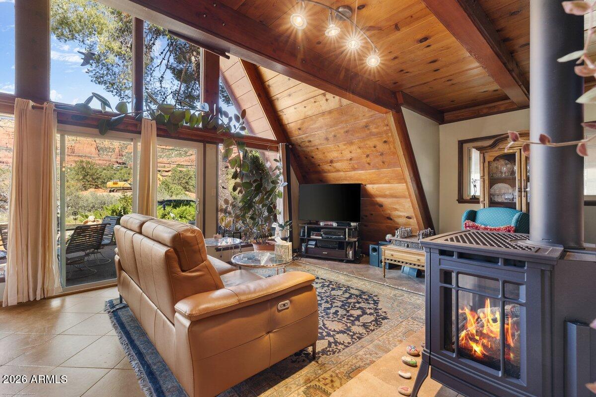 189 Wilson Canyon Road Sedona, AZ 86336 - Photo 5 of 47 a living room with furniture a fireplace and floor to ceiling windows