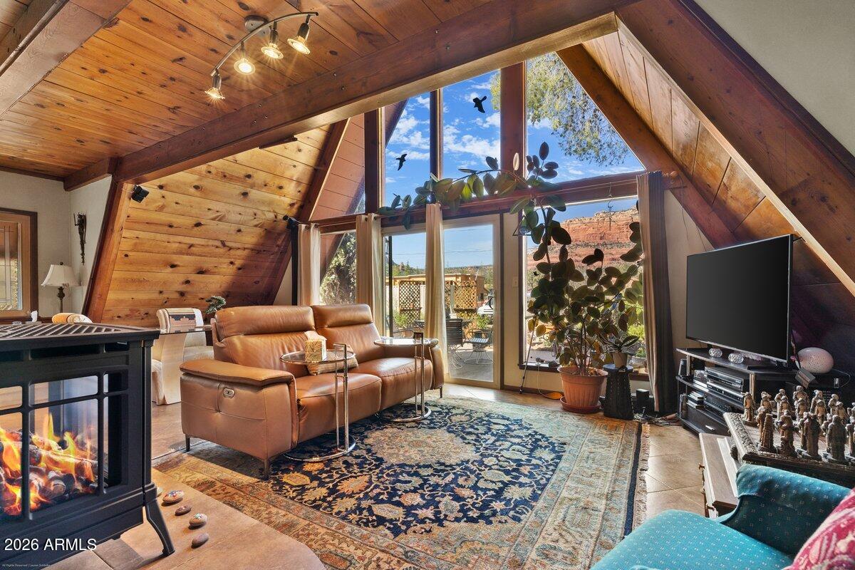 189 Wilson Canyon Road Sedona, AZ 86336 - Photo 6 of 47 a living room with furniture a flat screen tv and a floor to ceiling window