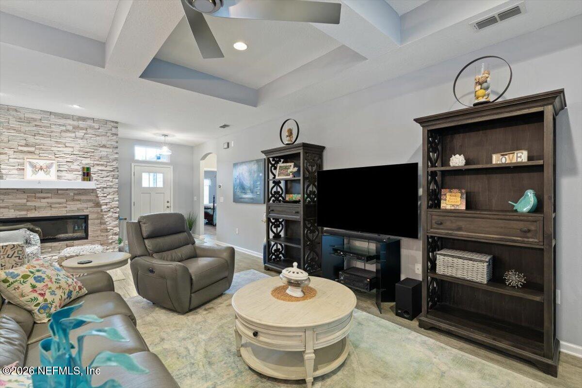 96085 Breezeway Court Yulee, FL 32097 - Photo 15 of 59 a living room with furniture a flat screen tv and a fireplace