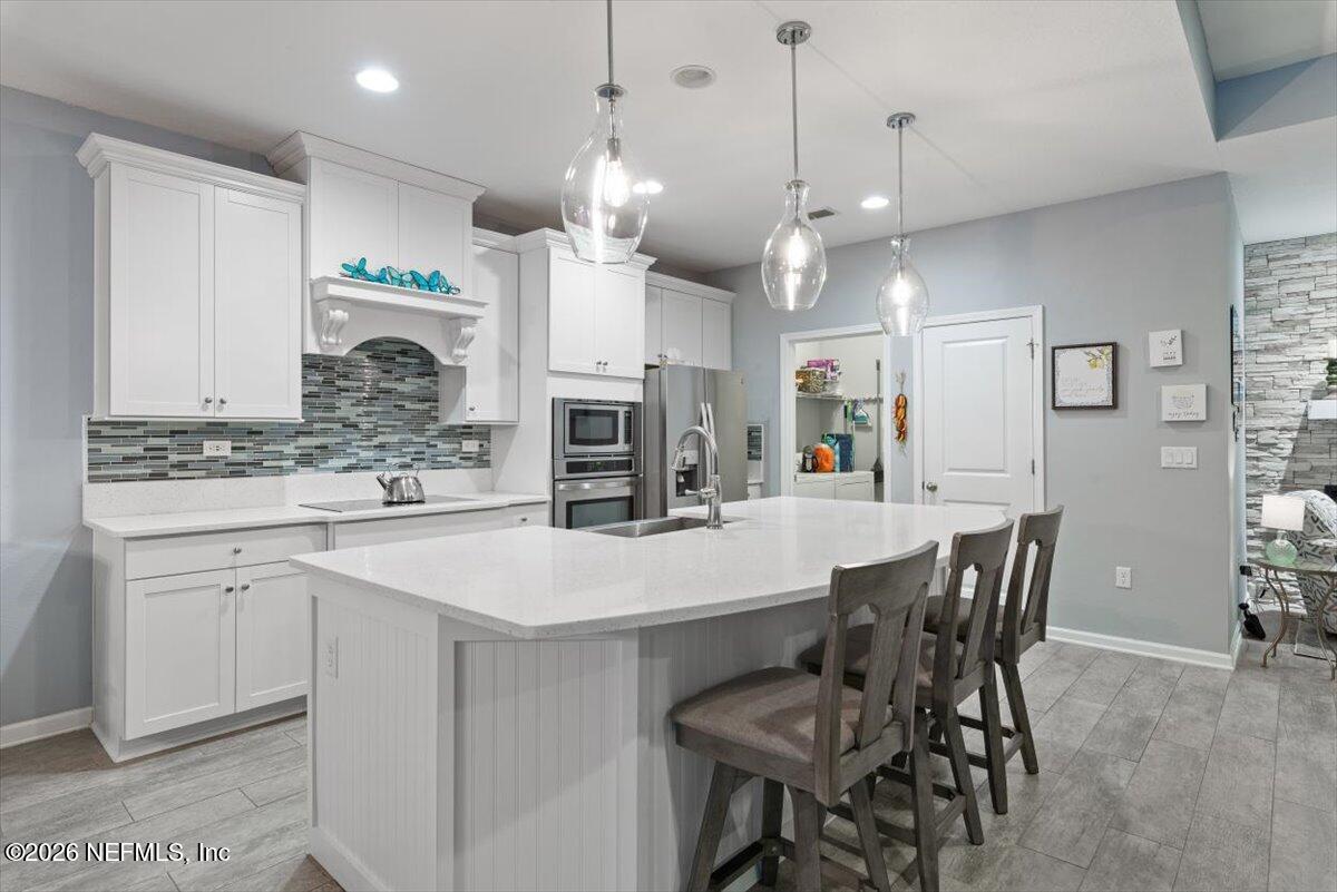 96085 Breezeway Court Yulee, FL 32097 - Photo 17 of 59 a large kitchen with kitchen island a dining table and chairs