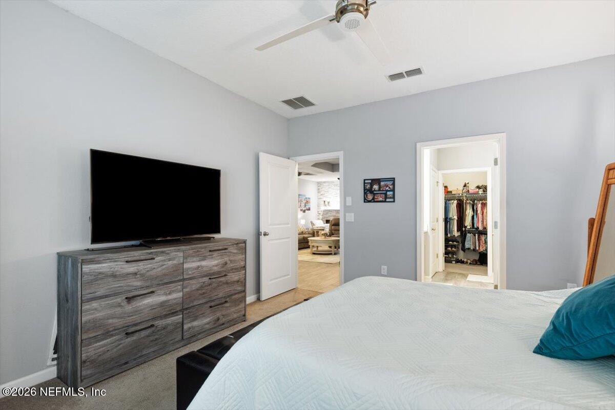 96085 Breezeway Court Yulee, FL 32097 - Photo 24 of 59 a bedroom with a bed and a flat screen tv