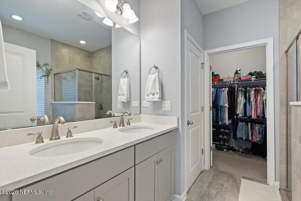 96085 Breezeway Court Yulee, FL 32097 - Photo 25 of 59 a bathroom with a sink double vanity and a mirror
