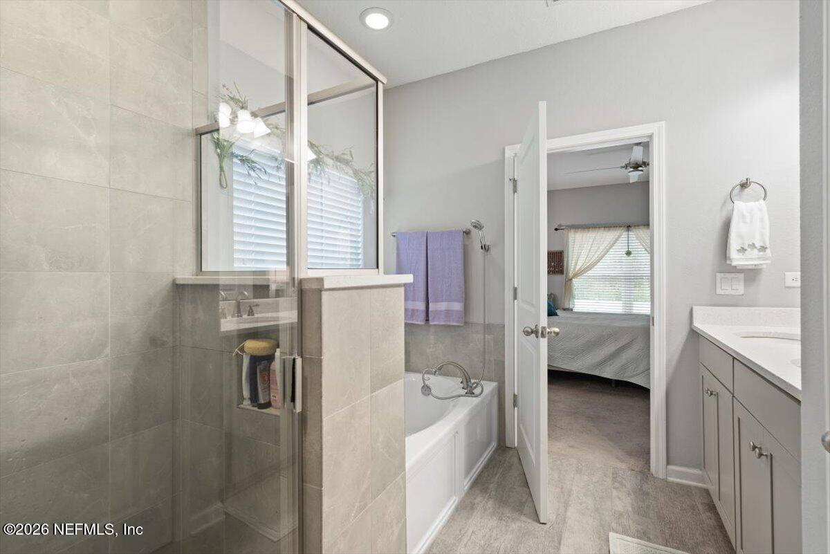 96085 Breezeway Court Yulee, FL 32097 - Photo 27 of 59 a bathroom with a tub sink and mirror