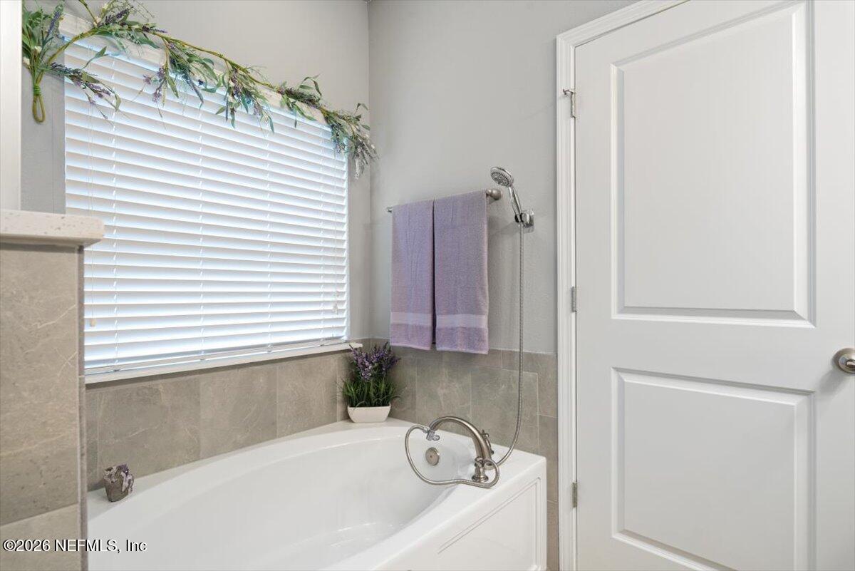 96085 Breezeway Court Yulee, FL 32097 - Photo 29 of 59 a bathroom with a bathtub and shower