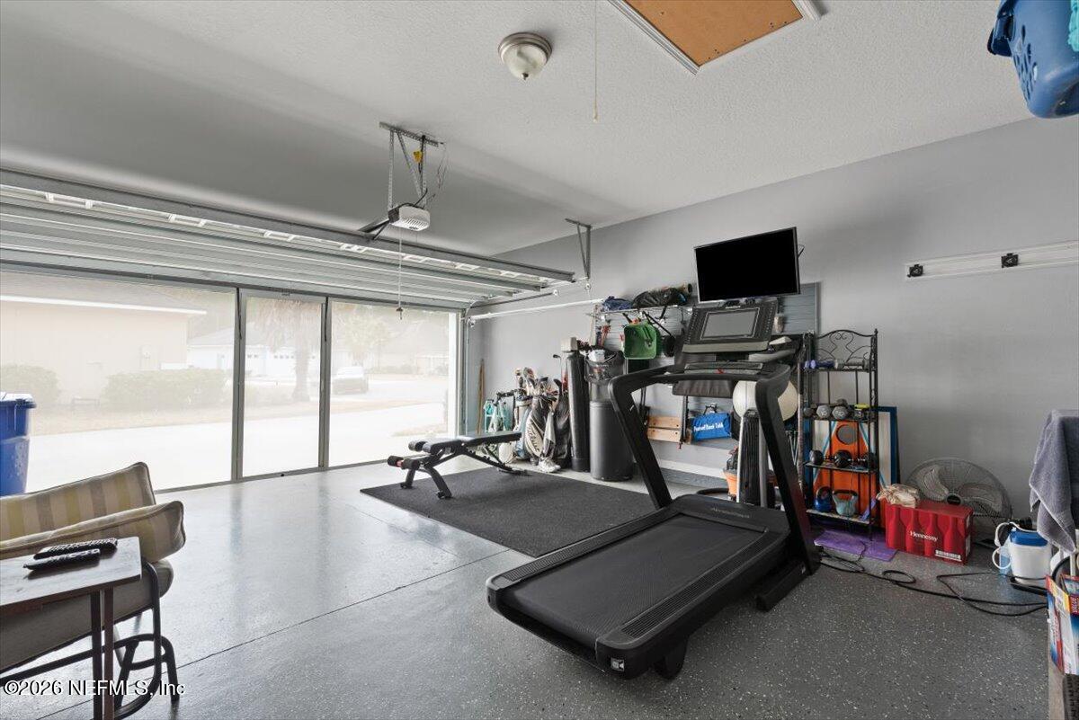 96085 Breezeway Court Yulee, FL 32097 - Photo 36 of 59 a room with gym equipment and a flat screen tv