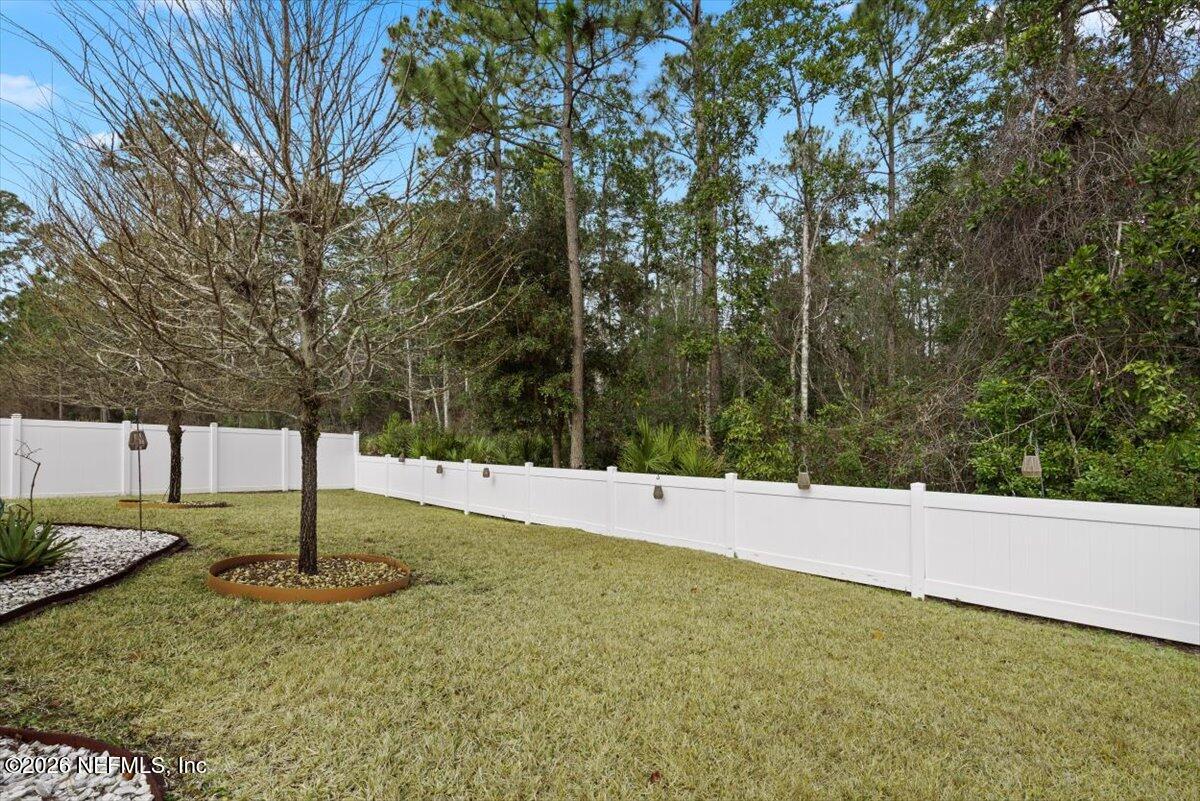 96085 Breezeway Court Yulee, FL 32097 - Photo 46 of 59 a backyard of a house with lots of green space
