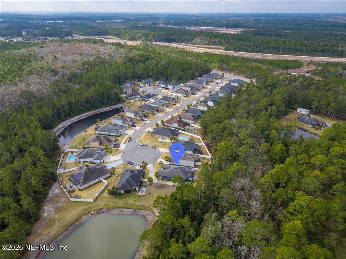 96085 Breezeway Court Yulee, FL 32097 - Photo 58 of 59 an aerial view of a house with a garden and lake view