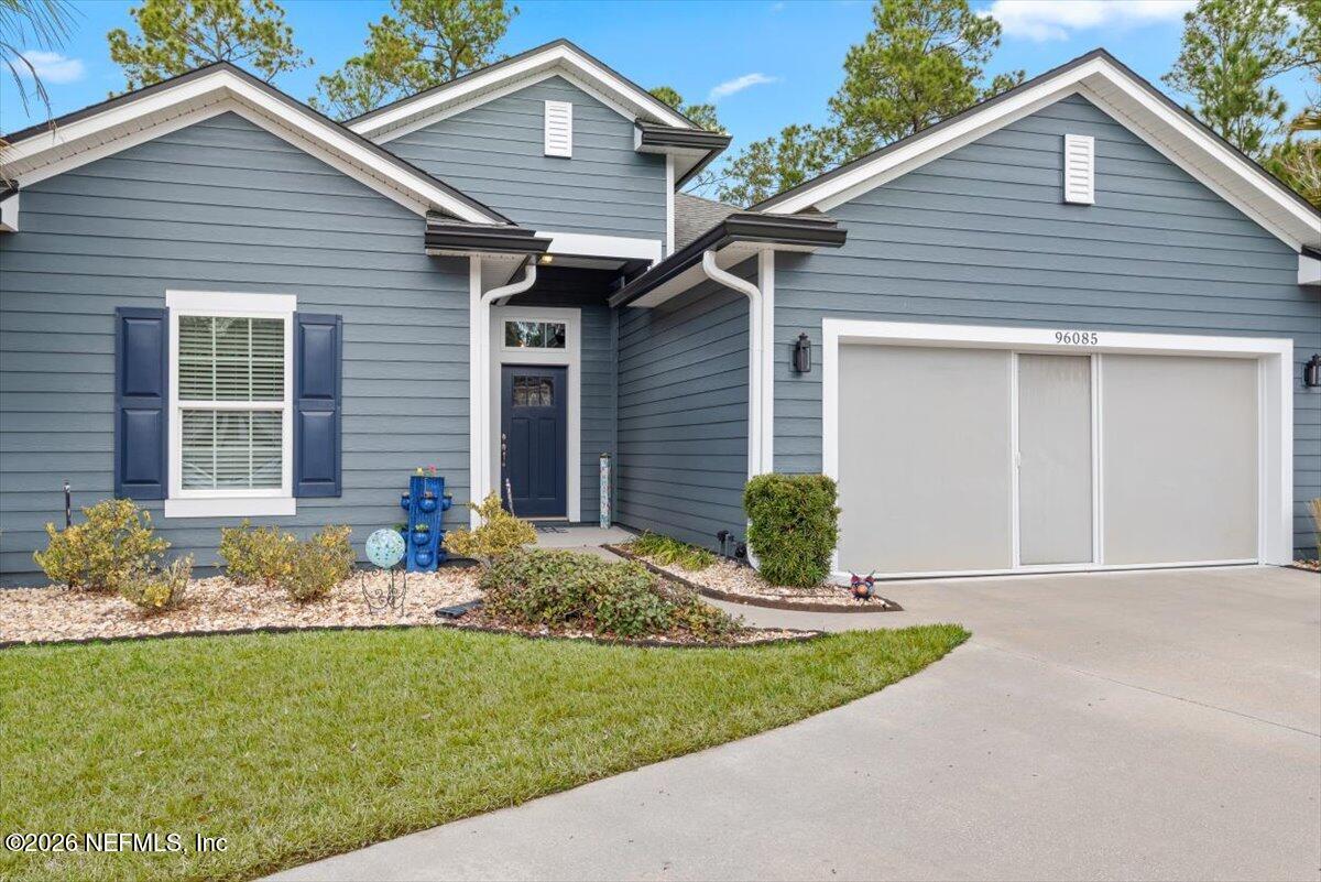 96085 Breezeway Court Yulee, FL 32097 - Photo 6 of 59 a front view of a house with garden