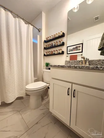 a white toilet sitting next to a bathroom sink