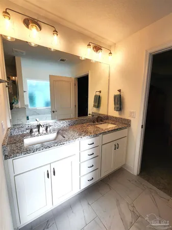 a bathroom with a granite countertop sink and a mirror