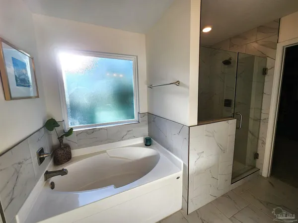 a bathroom with a tub a sink and mirror