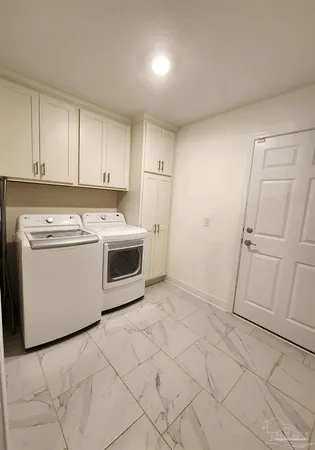 a utility room with cabinets washer and dryer