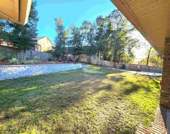 a view of yard with tree and wooden fence