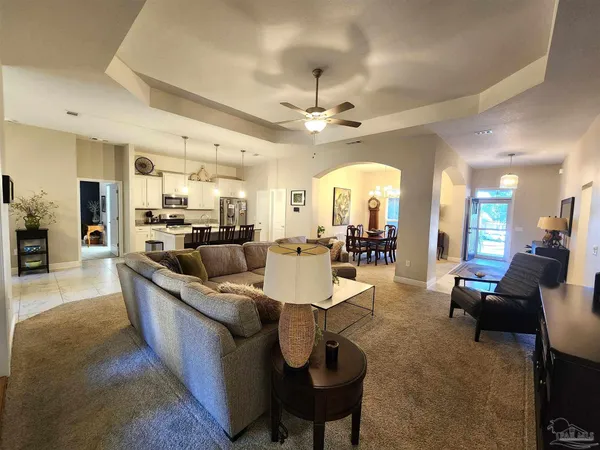 a large living room with stainless steel appliances kitchen island granite countertop furniture a fireplace and a large window