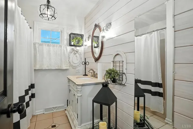 a living room with lots of wooden furniture and a chandelier