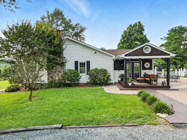 a kitchen with stainless steel appliances granite countertop a refrigerator a sink dishwasher a stove and white countertops with wooden floor