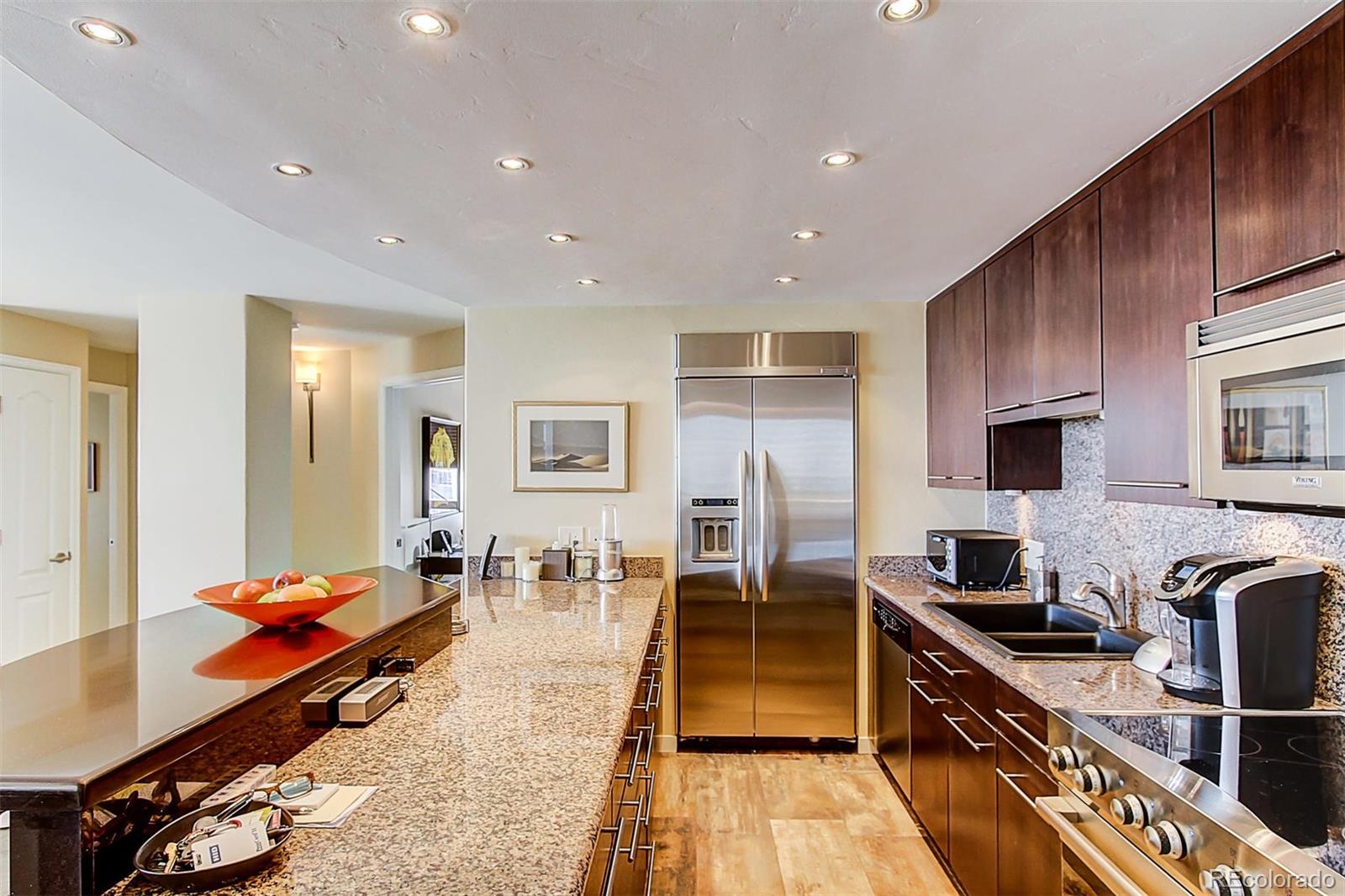 a large kitchen with stainless steel appliances granite countertop a stove and a sink