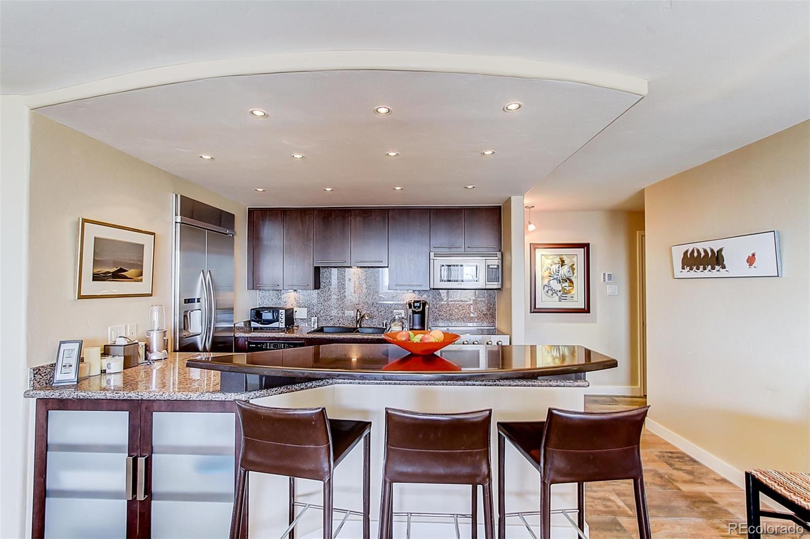 1020 15th Street, Unit 25J Denver, CO 80202 - Photo 15 of 34 a dining hall with stainless steel appliances a dining table and chairs with kitchen island