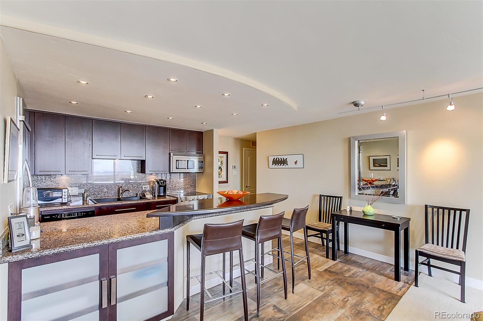 1020 15th Street, Unit 25J Denver, CO 80202 - Photo 16 of 34 a kitchen with stainless steel appliances a table and chairs in it
