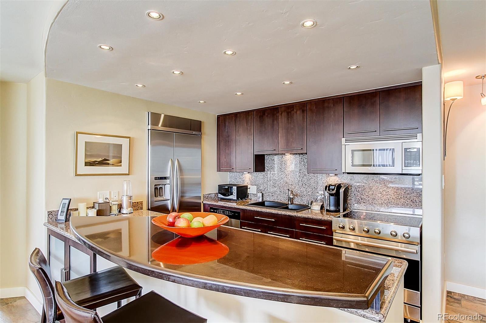 1020 15th Street, Unit 25J Denver, CO 80202 - Photo 17 of 34 a kitchen with stainless steel appliances granite countertop a stove a sink and a refrigerator