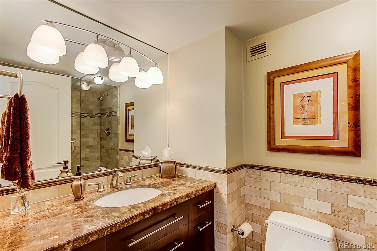 1020 15th Street, Unit 25J Denver, CO 80202 - Photo 19 of 34 a bathroom with a granite countertop sink and a mirror