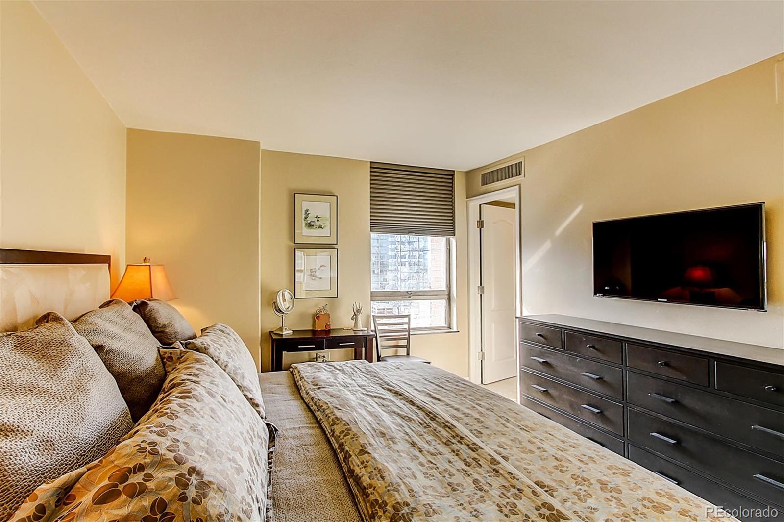 1020 15th Street, Unit 25J Denver, CO 80202 - Photo 24 of 34 a bedroom with a bed and a flat screen tv