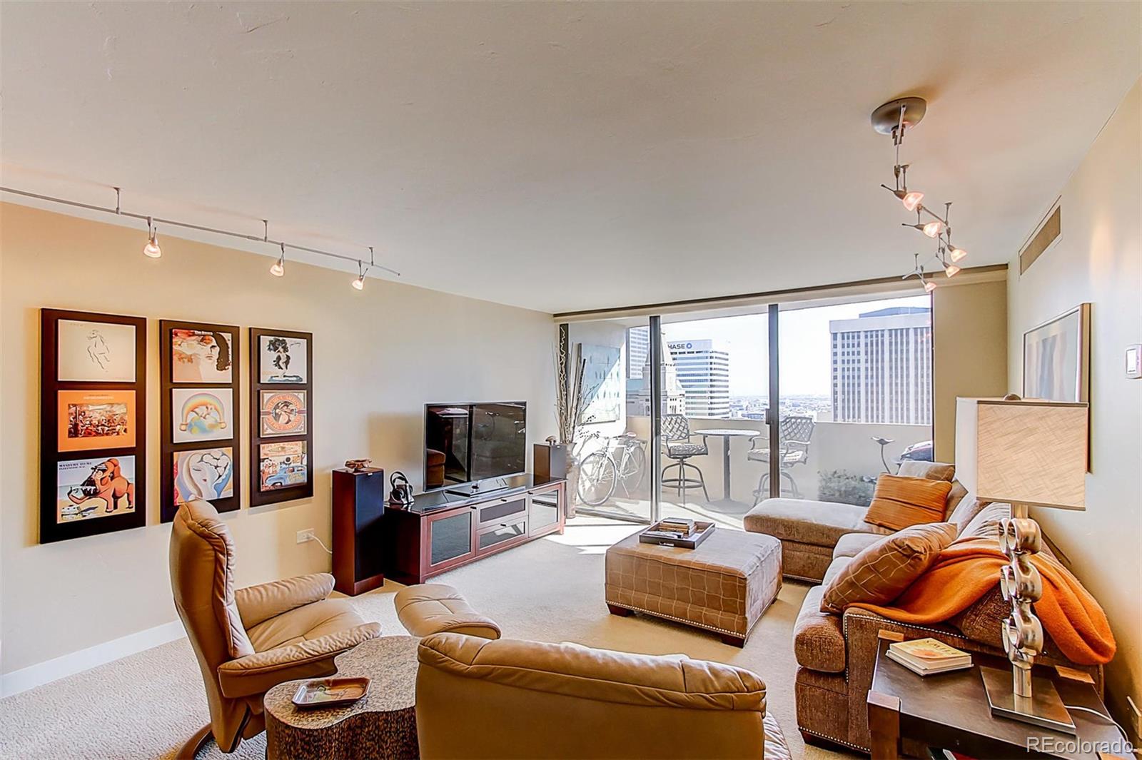 1020 15th Street, Unit 25J Denver, CO 80202 - Photo 4 of 34 a living room with furniture flat screen tv and a large window