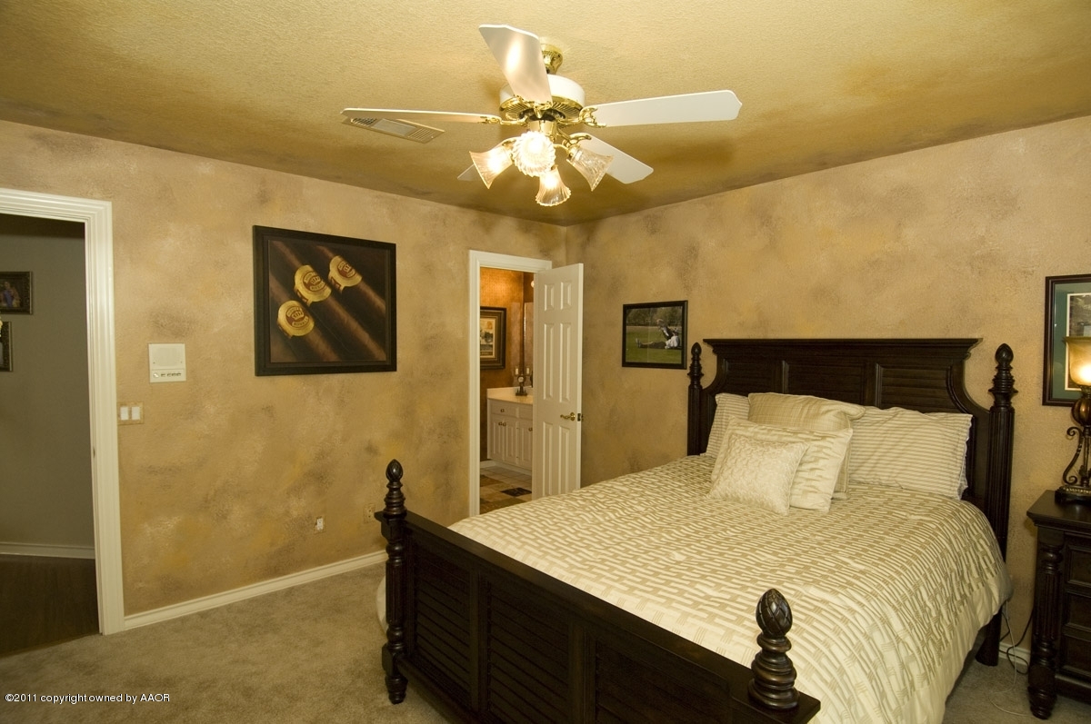 7821 Covington Parkway Amarillo, TX 79121 - Photo 11 of 53 a bedroom with a bed and a chandelier