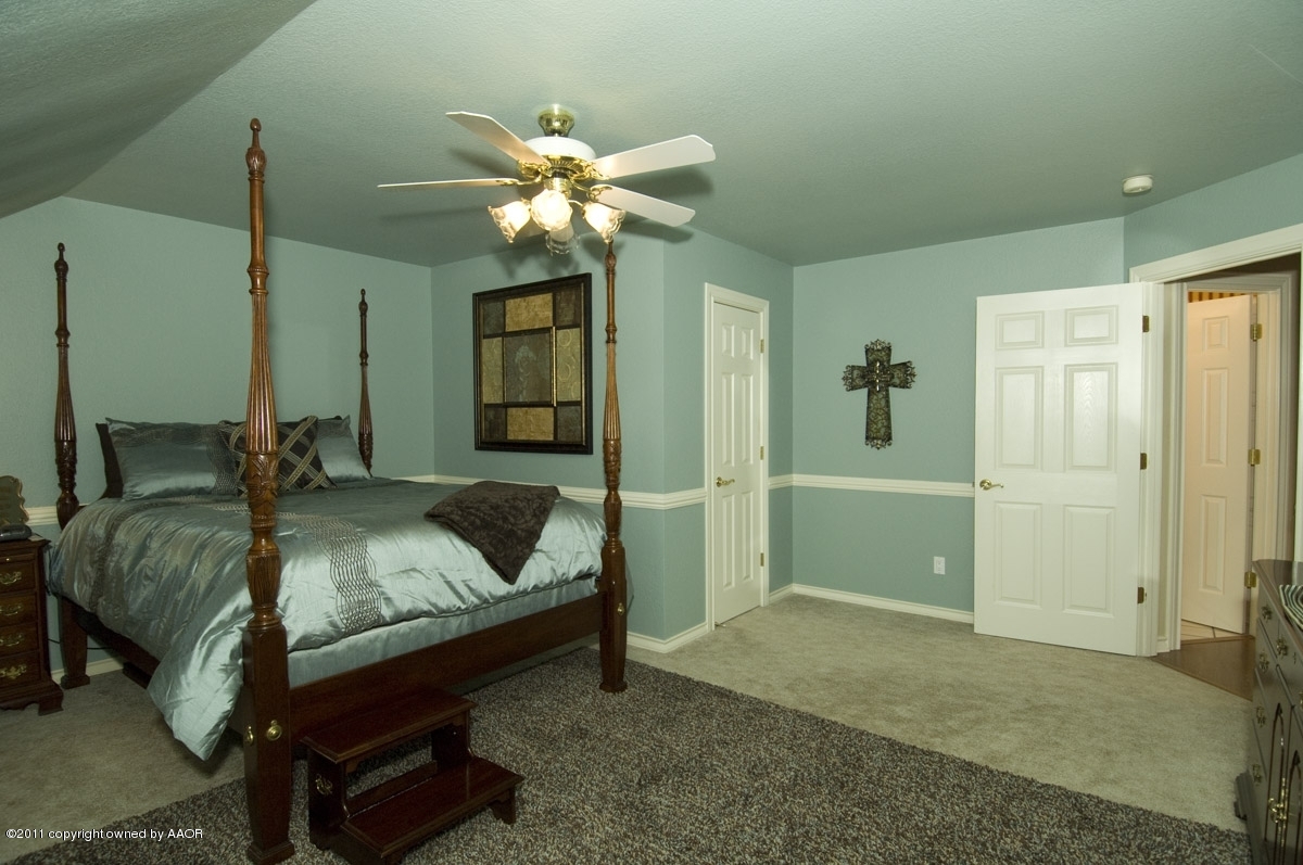 7821 Covington Parkway Amarillo, TX 79121 - Photo 9 of 53 a bedroom with a bed and a chandelier