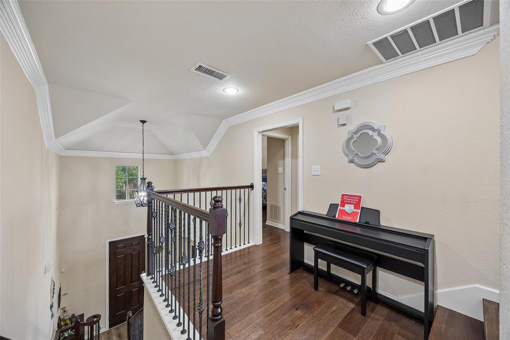 2865 Ridge View Road Frisco, TX 75034 - Photo 24 of 38 Wood-finish flooring, recessed lighting, crown molding, iron balusters, and a vaulted ceiling