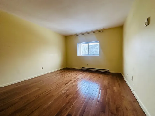 a view of a room with wooden floor and window