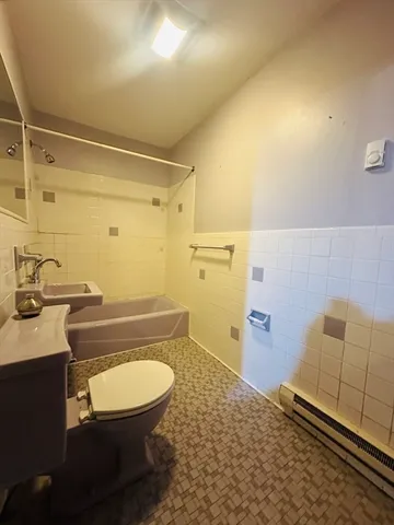 a bathroom with a granite countertop toilet sink and mirror