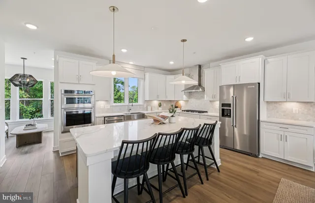 a view of a dining room with furniture a kitchen and chandelier