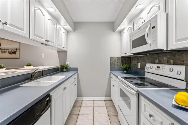 a kitchen with stainless steel appliances granite countertop a sink a stove and cabinets